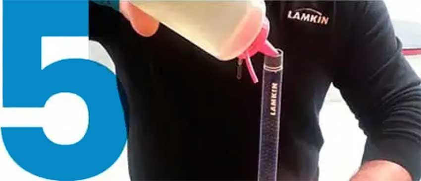 tech pouring mineral spirits inside a Lamkin grip