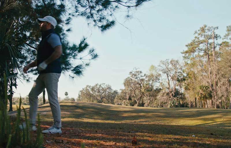 golfer looking for ball in the woods